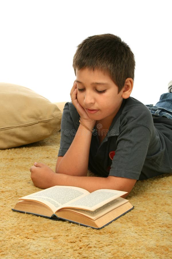 Jongen die een boek op de vloer leest stock foto's Jongen die een boek op de vloer leest stock foto's