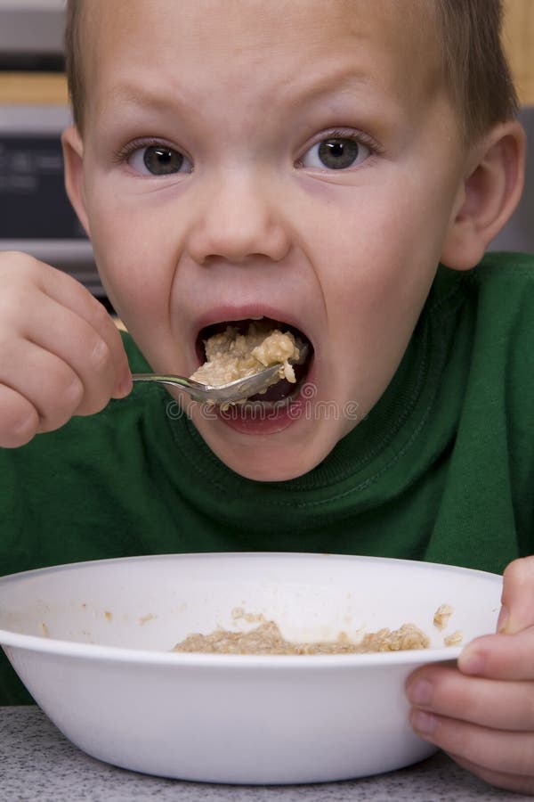Jongen die havermeel grote beet eet royalty-vrije stock afbeelding Jongen die havermeel grote beet eet royalty-vrije stock afbeelding