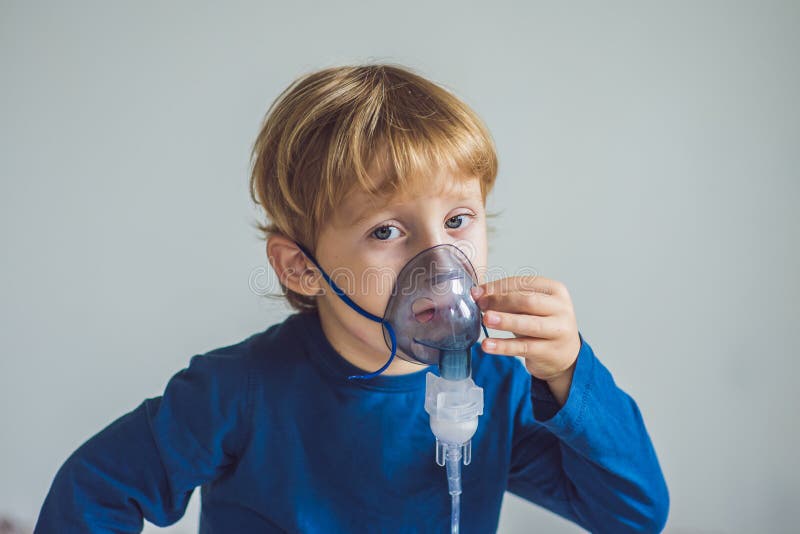 Jongen die inhalatie met een verstuiver thuis maken royalty-vrije stock fotografie Jongen die inhalatie met een verstuiver thuis maken royalty-vrije stock fotografie