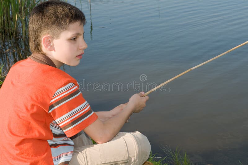 Jongen die op de vijver vist stock foto Jongen die op de vijver vist stock foto