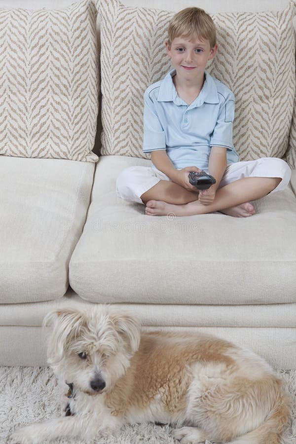 Little boy watching television while dog sitting on rug at home. Little boy watching television while dog sitting on rug at home