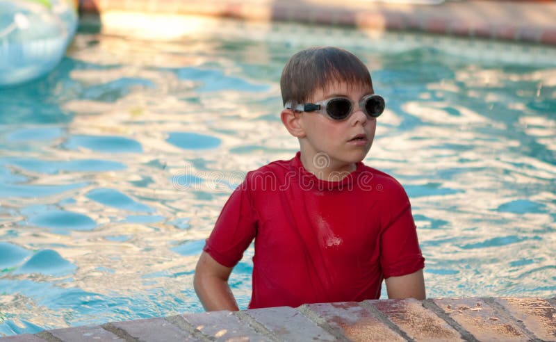 Jongen die rode overhemd en beschermende brillen in pool draagt stock afbeeldingen Jongen die rode overhemd en beschermende brillen in pool draagt stock afbeeldingen