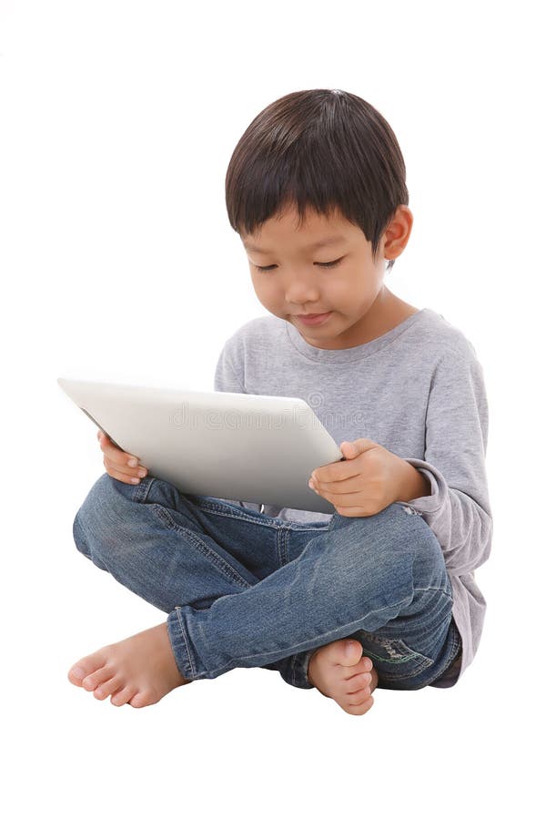 Jongen die tablet gebruiken terwijl het zitten stock fotografie Jongen die tablet gebruiken terwijl het zitten stock fotografie