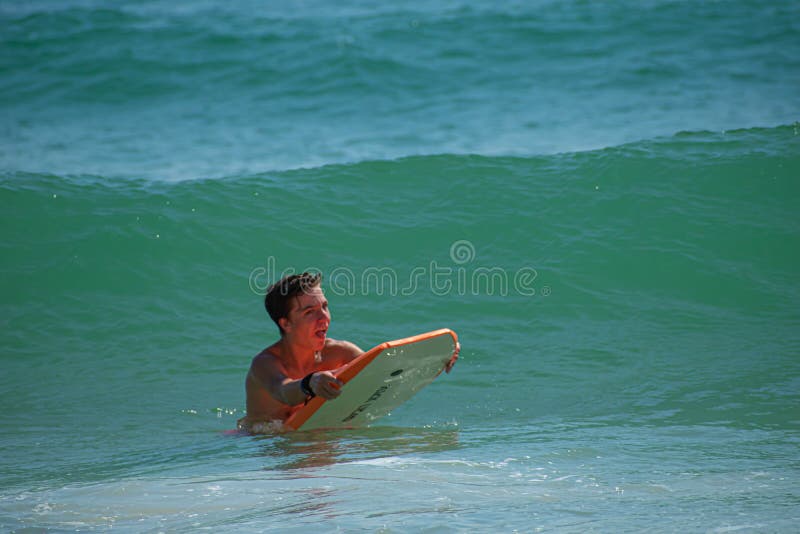 Daytona Beach Florida. July 07, 2019 Boy enjoying waves with surfboard at Main Street Pier area 3. Daytona Beach Florida. July 07, 2019 Boy enjoying waves with surfboard at Main Street Pier area 3