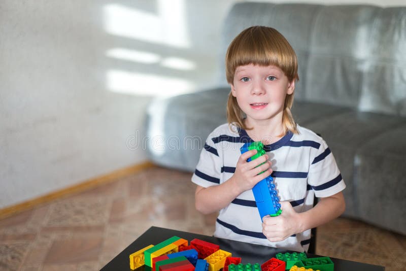 Jongen het spelen met veel kleurrijke plastic blokken binnen stock afbeelding Jongen het spelen met veel kleurrijke plastic blokken binnen stock afbeelding