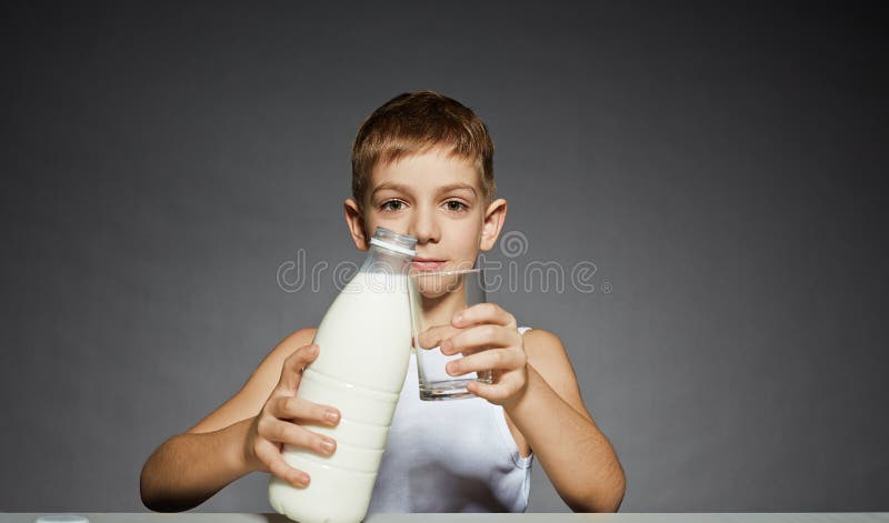 Jongen met melkfles en glas royalty-vrije stock afbeeldingen Jongen met melkfles en glas royalty-vrije stock afbeeldingen