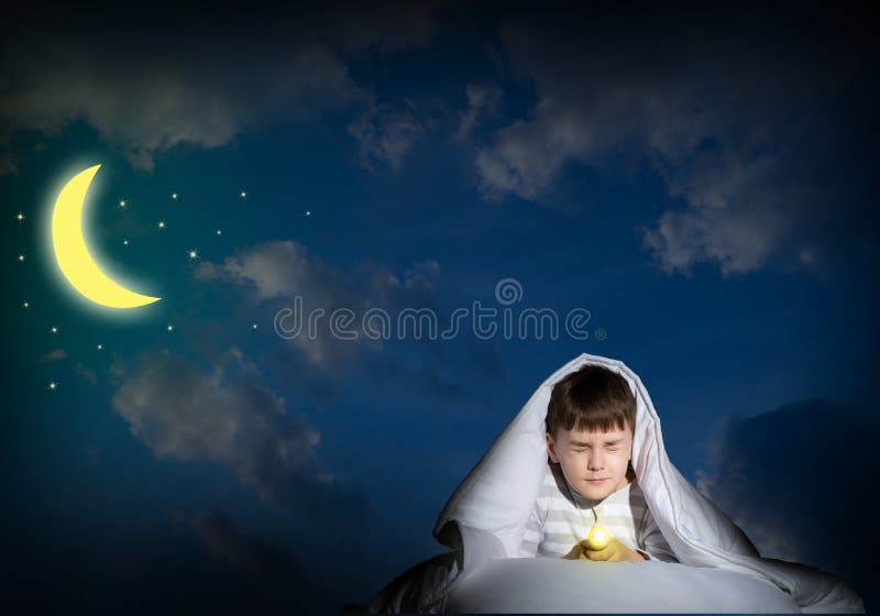 Image of a frightened boy under the covers with a flashlight. Image of a frightened boy under the covers with a flashlight