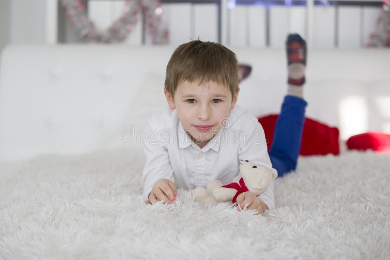 Jongen preschoolaar ligt op het bed met een stuk speelgoed stock afbeeldingen Jongen preschoolaar ligt op het bed met een stuk speelgoed stock afbeeldingen