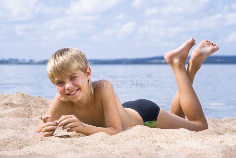 Jongen in zand op kust