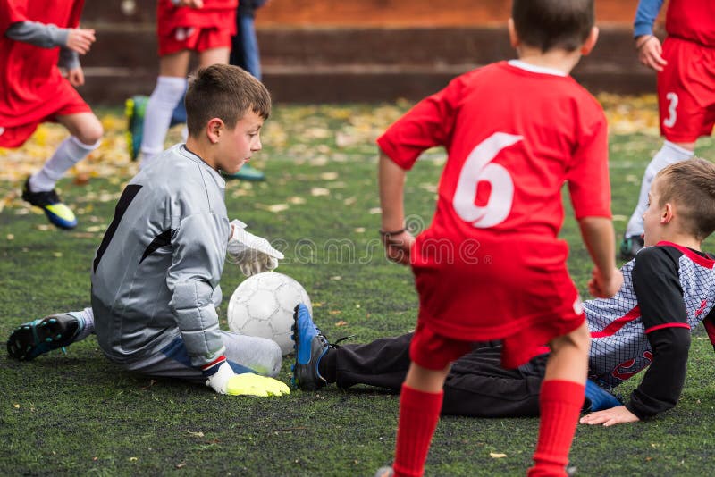 Jongens die voetbalbal schoppen bij sportterrein royalty-vrije stock foto Jongens die voetbalbal schoppen bij sportterrein royalty-vrije stock foto
