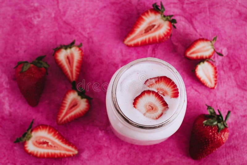 Jordgubbemilkshake i den rosa bakgrunden för exponeringsglaskrus royaltyfria foton Jordgubbemilkshake i den rosa bakgrunden för exponeringsglaskrus royaltyfria foton
