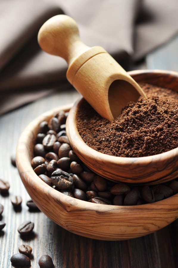 Ground coffee and coffee beans in bowls on wooden background. Ground coffee and coffee beans in bowls on wooden background