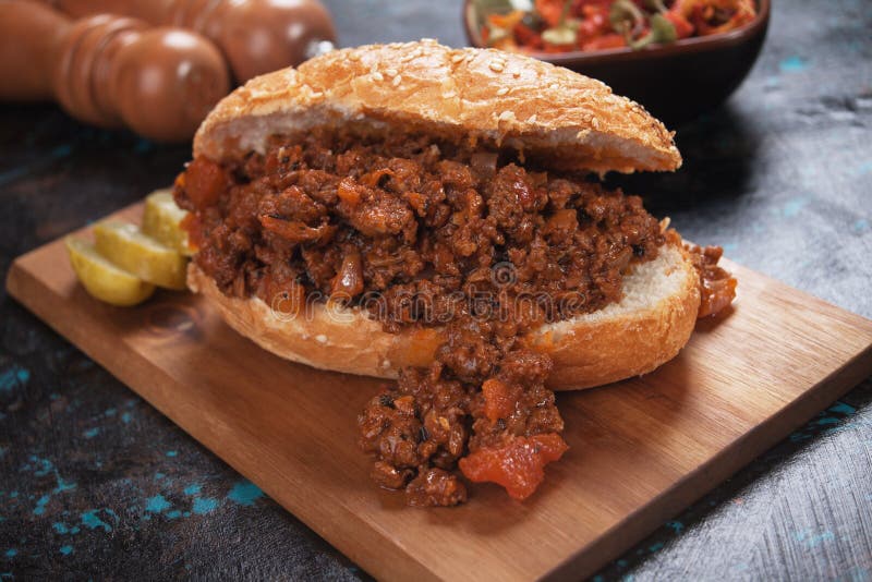 Ground beef sandwich served on wooden board. Ground beef sandwich served on wooden board