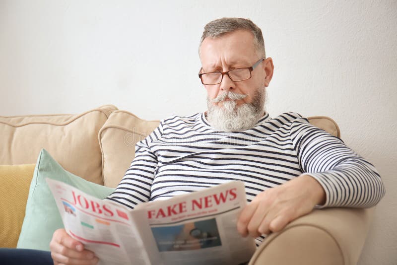 Jornal da leitura do homem s?nior em casa foto de stock Jornal da leitura do homem s?nior em casa foto de stock