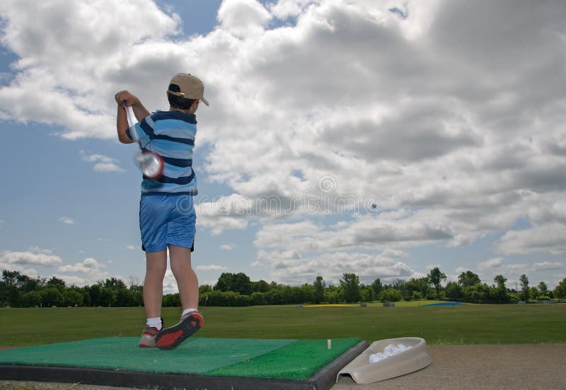 Jouer au golf de gosse photographie stock Jouer au golf de gosse photographie stock