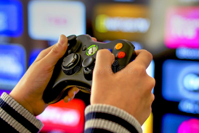 Jouer des jeux vidéo sur la console de Xbox, fond de TV photo stock Jouer des jeux vidéo sur la console de Xbox, fond de TV photo stock