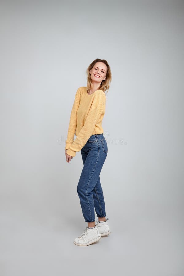 Jouer et sourire Un portrait dans intégral d'une belle blonde, habillé dans des vêtements élégants poses devant le blanc images libres de droits Jouer et sourire Un portrait dans intégral d'une belle blonde, habillé dans des vêtements élégants poses devant le blanc images libres de droits