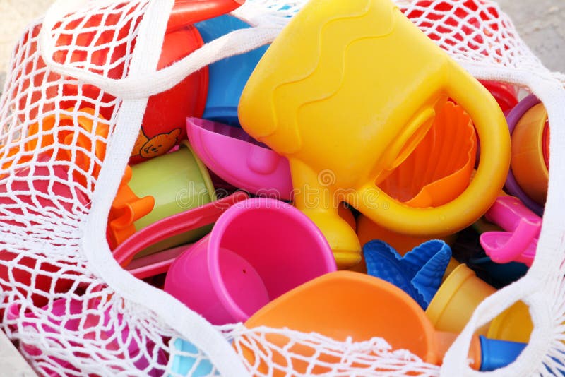 A netted basket full of toys used by children for water play. A netted basket full of toys used by children for water play