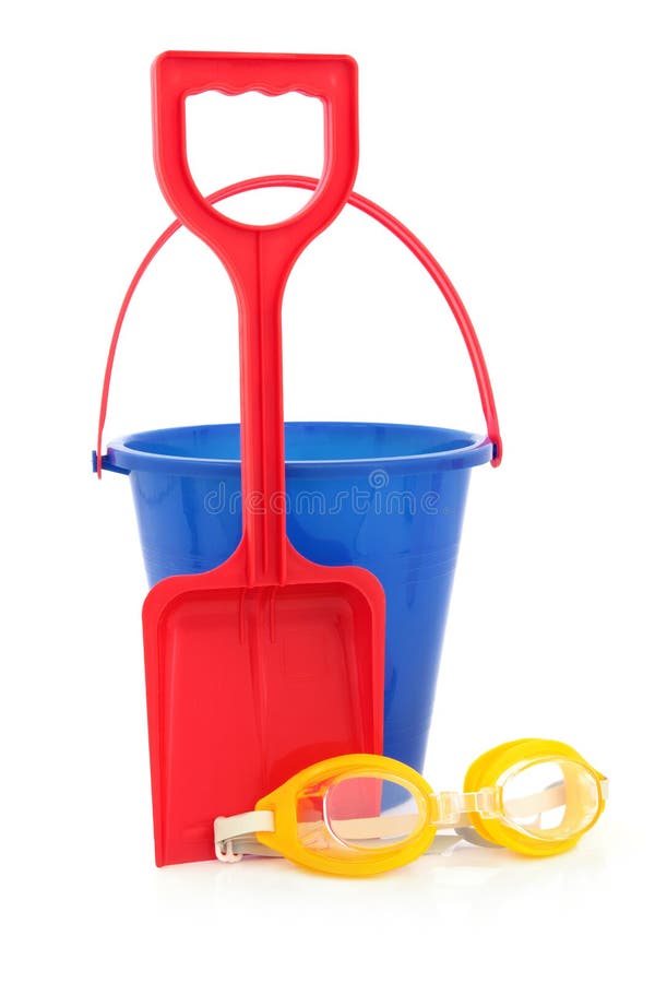 Bucket and spade beach toys with protective swimming goggles over white background. Bucket and spade beach toys with protective swimming goggles over white background.