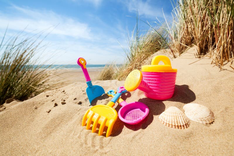 Summer beach toys in the sand concept for holiday and vacations. Summer beach toys in the sand concept for holiday and vacations