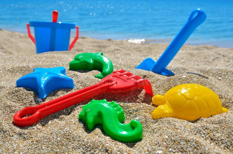 Baby beach toys on the sand against the blue sea. Baby beach toys on the sand against the blue sea