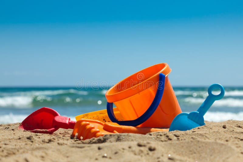 Children's beach toys - buckets, spade and shovel on sand on a sunny day. Children's beach toys - buckets, spade and shovel on sand on a sunny day