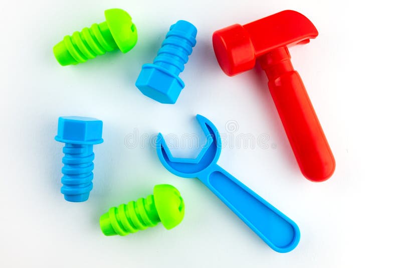 Jouets pour enfants sur un fond blanc, un marteau rouge, une cl? bleue, deux boulons bleus et deux verts Outils pour la r?paratio photos libres de droits Jouets pour enfants sur un fond blanc, un marteau rouge, une cl? bleue, deux boulons bleus et deux verts Outils pour la r?paratio photos libres de droits