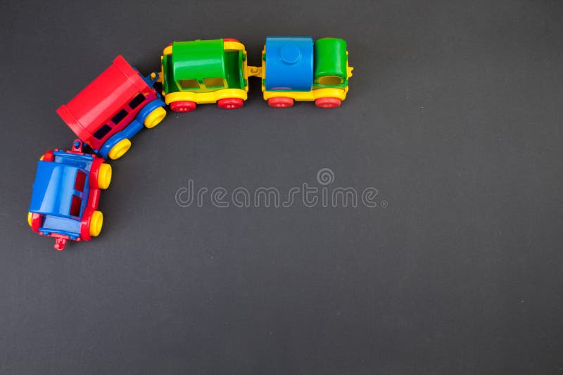 Children's toy, a multi-colored steam locomotive on a black background. For the development of the child. Children's toy, a multi-colored steam locomotive on a black background. For the development of the child