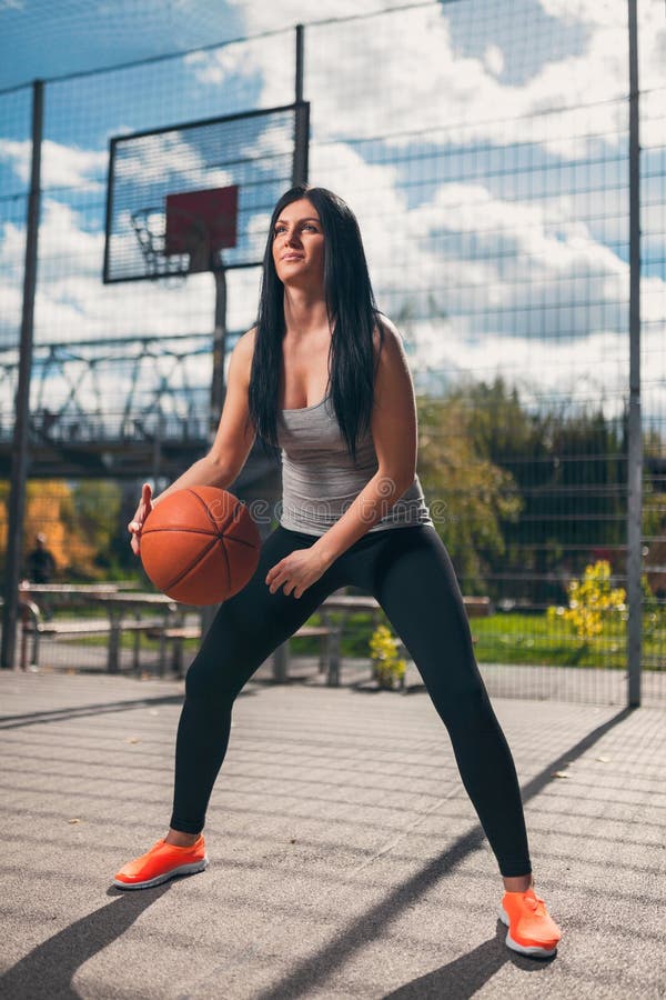 Joueur de basket féminin s'exerçant dehors sur une cour locale photo libre de droits Joueur de basket féminin s'exerçant dehors sur une cour locale photo libre de droits