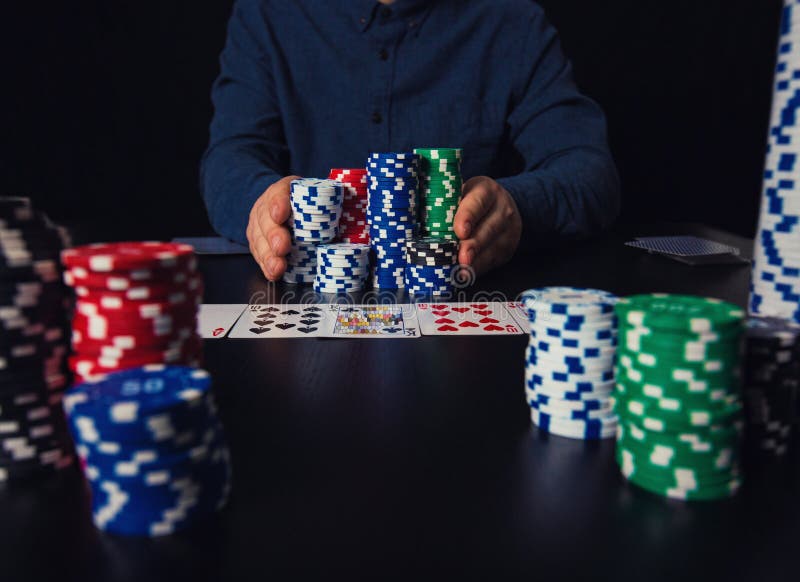Joueur de poker risqué de type allant tout compris poussant sa grande pile de puces en avant, pariant à la table de jeu de casino image libre de droits Joueur de poker risqué de type allant tout compris poussant sa grande pile de puces en avant, pariant à la table de jeu de casino image libre de droits