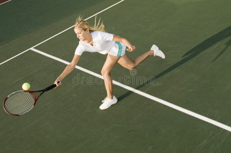 Joueur de tennis atteignant pour frapper la boule images libres de droits Joueur de tennis atteignant pour frapper la boule images libres de droits