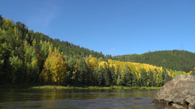 Jour d'automne ensoleillé sur la rive du fleuve Ciel bleu, rivière calme et montagnes recouvertes de forêt