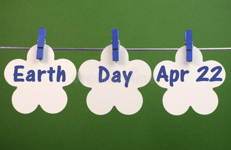 Jour de terre, le 22 avril, la salutation de message écrite à travers la fleur blanche carde pendre des chevilles sur une ligne