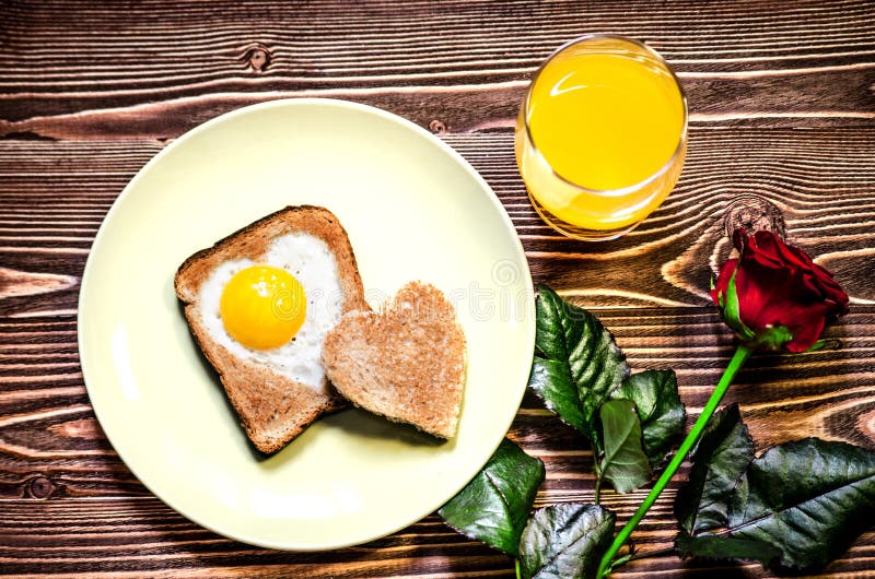 Jour du ` s de Valentine de petit déjeuner Du plat est le pain grillé avec des oeufs au plat à l'intérieur d'un coeur Après du pl photos libres de droits Jour du ` s de Valentine de petit déjeuner Du plat est le pain grillé avec des oeufs au plat à l'intérieur d'un coeur Après du pl photos libres de droits