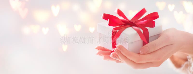 Jour du `s de Valentine Femme tenant le boîte-cadeau avec l'arc rouge