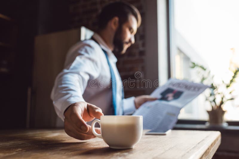 journal concentré de lecture d'homme d'affaires sur la cuisine dans le matin tout en ayant la tasse image libre de droits journal concentré de lecture d'homme d'affaires sur la cuisine dans le matin tout en ayant la tasse image libre de droits