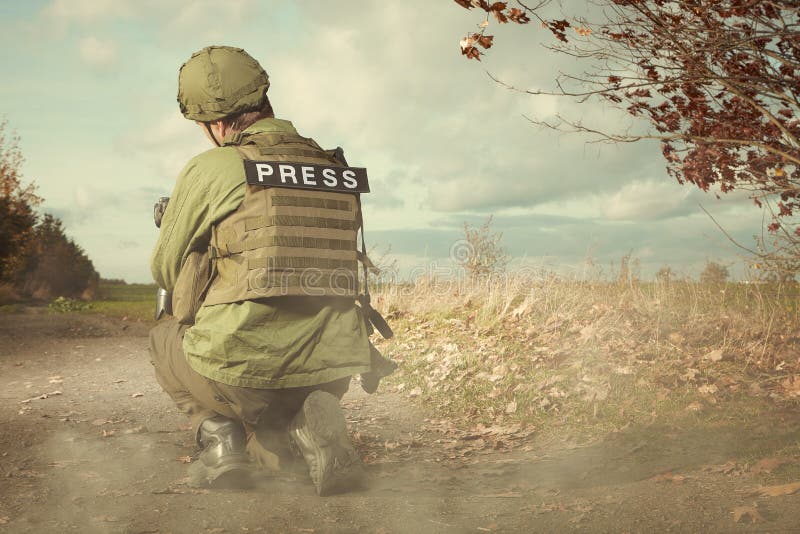 Journalist photographer in war conflict zone between shootings