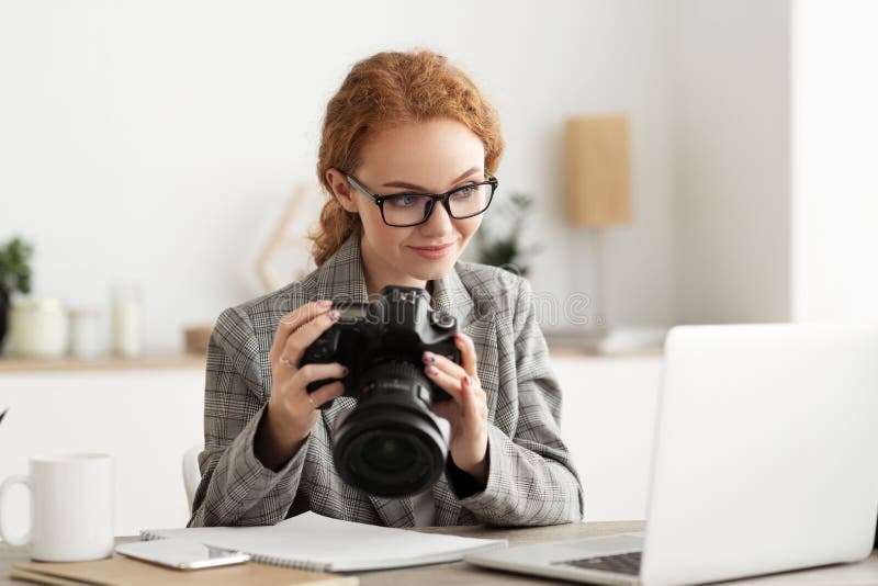Journalist transfering image data on camera to laptop stock photos
