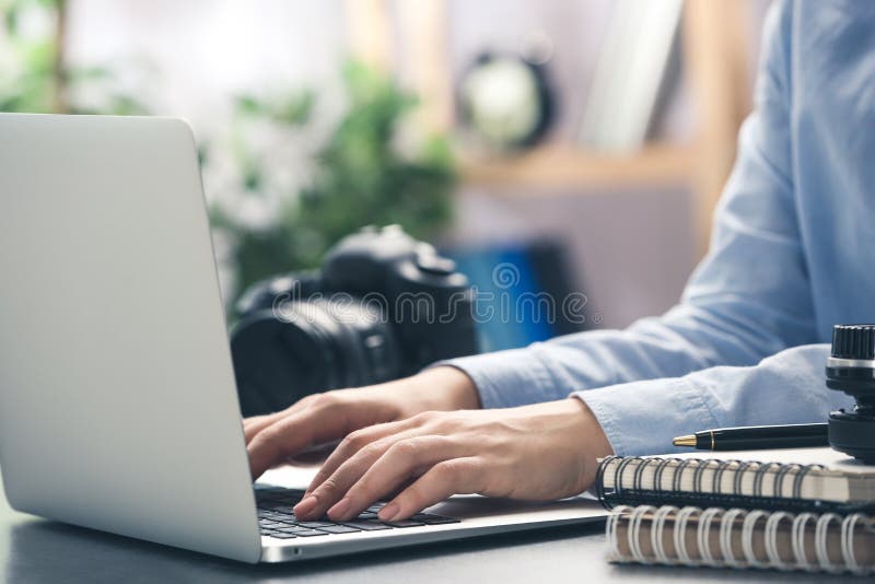 Journalist working with laptop at table stock photo