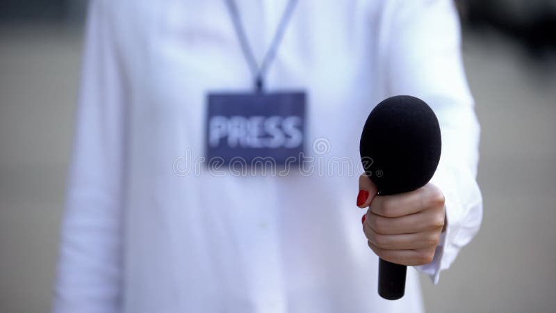 Journalister med press-ID som föreslår mikrofon för intervju, tv-nyheter