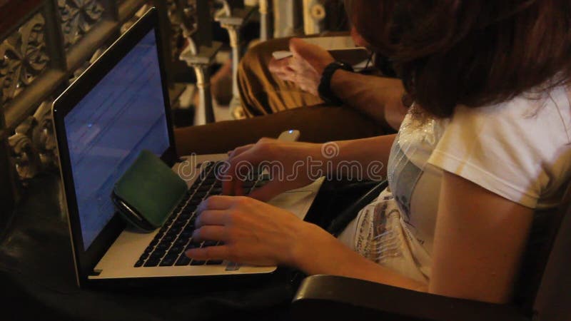 Journalistkvinnan skriver på bärbara datorn