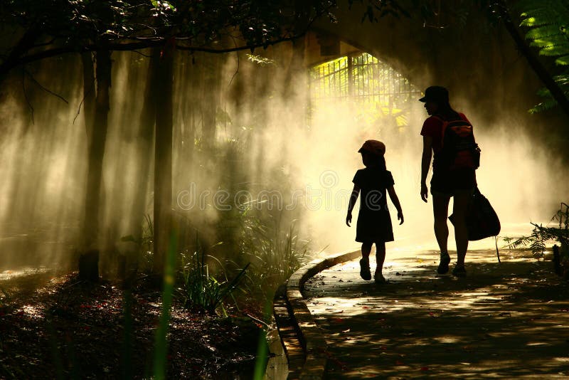 Mamma prendendo bambina nel giardino mistico per esplorare la terra di fantasia.