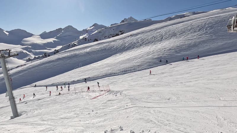 Journée ensoleillée dans la neige des montagnes enneigées à la station de ski de nombreux skieurs sur la pente