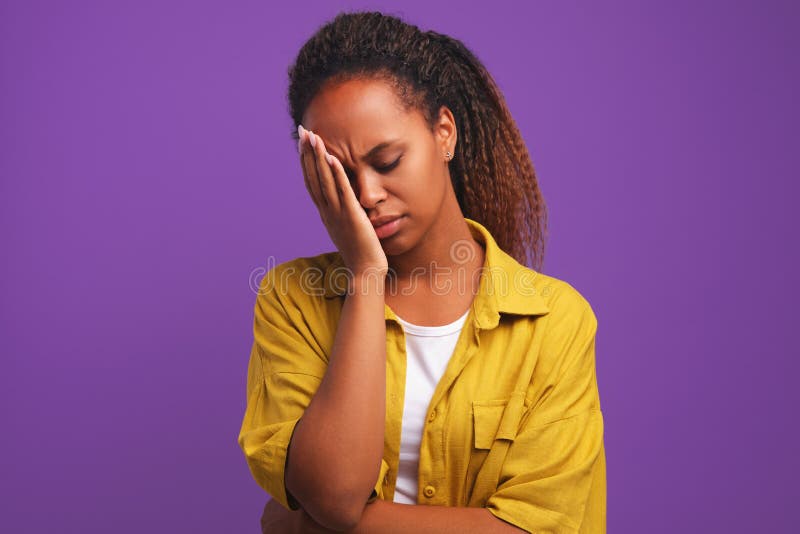 Só o café pode me refrescar. mulher afro-americana sonolenta e cansada  cobre metade do rosto com a palma da mão, tem expressão triste, fecha os  olhos, carrega um copo descartável de bebida com cafeína, continua  trabalhando.