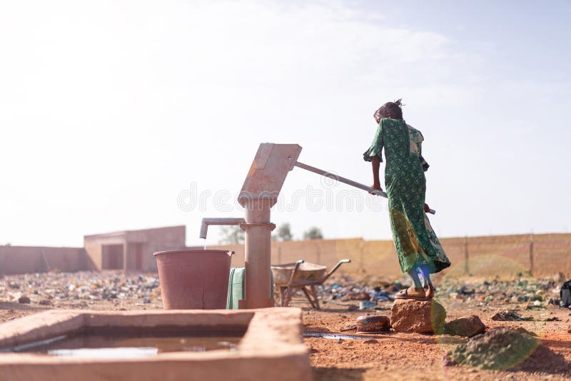 Jovem africana feliz carregando água saudável em uma vila
