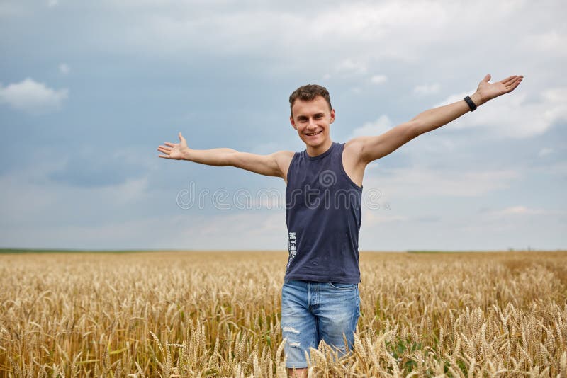 Jovem agricultor no campo de trigo imagem de stock royalty free Jovem agricultor no campo de trigo imagem de stock royalty free