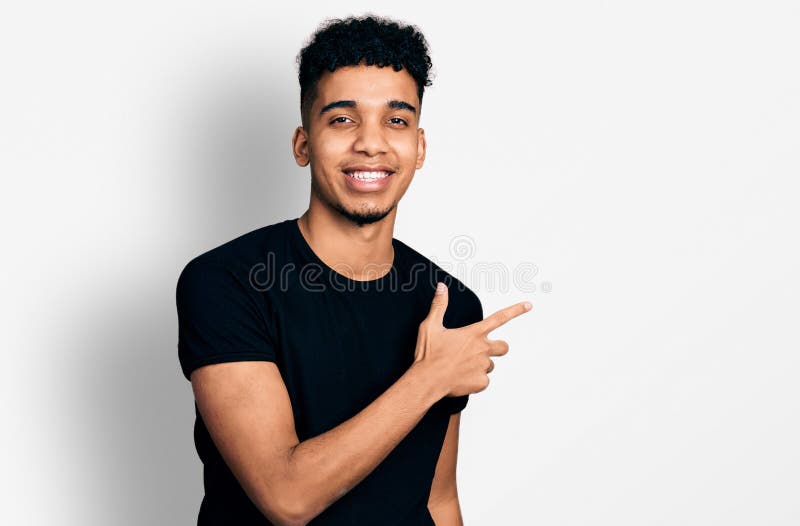 Young african american man wearing casual black t shirt smiling cheerful pointing with hand and finger up to the side. Young african american man wearing casual black t shirt smiling cheerful pointing with hand and finger up to the side