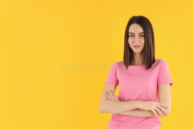 Jovem mulher atraente em t-shirt sobre fundo amarelo fotografia de stock
