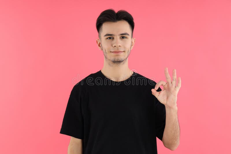 Jovem atraente em camisa de fundo rosa foto de stock