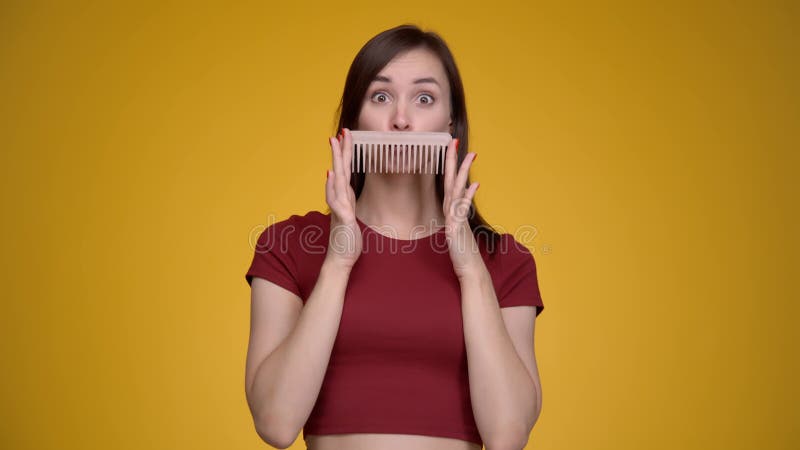 Jovem atraente se divertindo com pincel de cabelo.